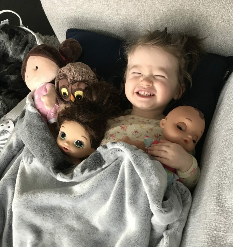 Baby girl prentending to sleep with her dolls