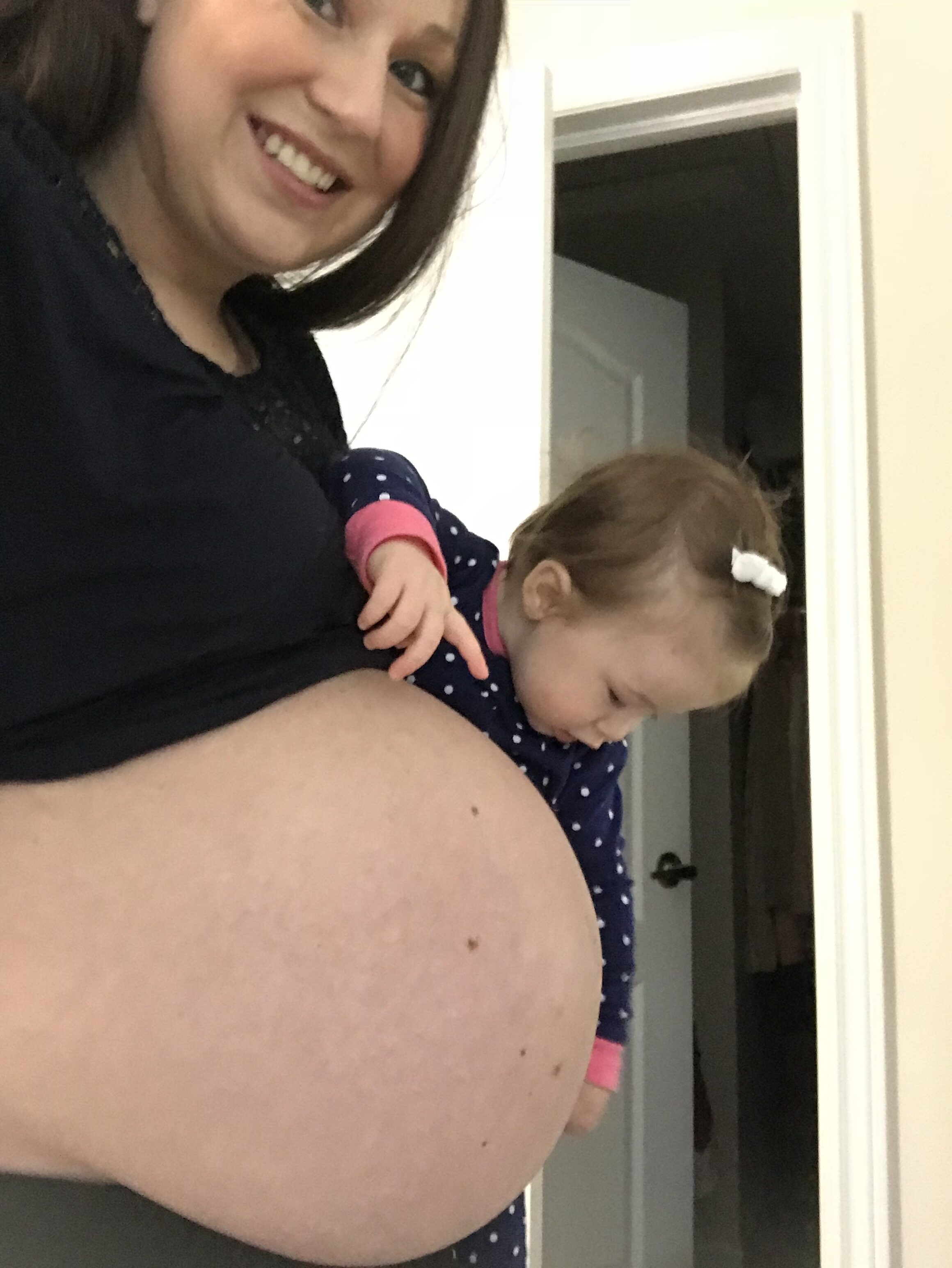 Picture of myself with my pregnant belly and first baby daughter holding my belly