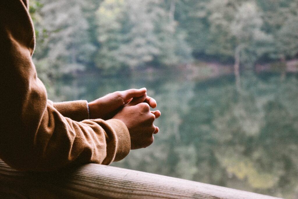 Image shows hands, person is considering ways they may be holding themselves back. Self reflection, self discovery and considering current mindset.